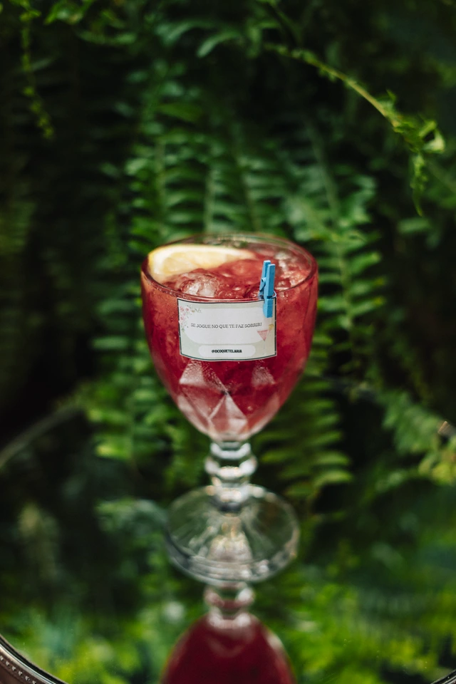 Drink vermelho servido em taça de cristal