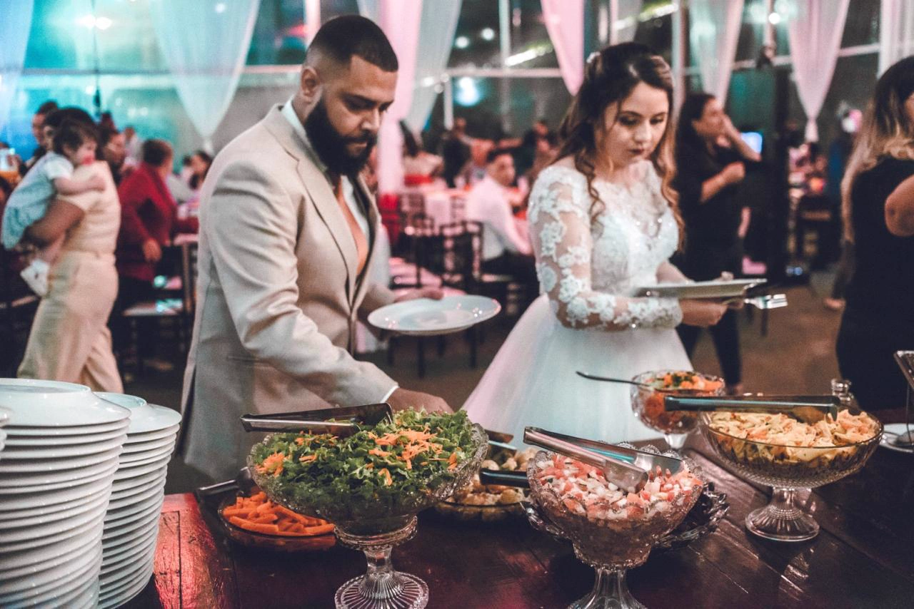 Casal se servindo no buffet da Emeny's Eventos