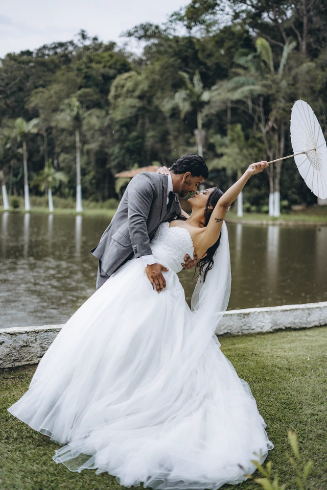 Noivos se beijando à beira do lago