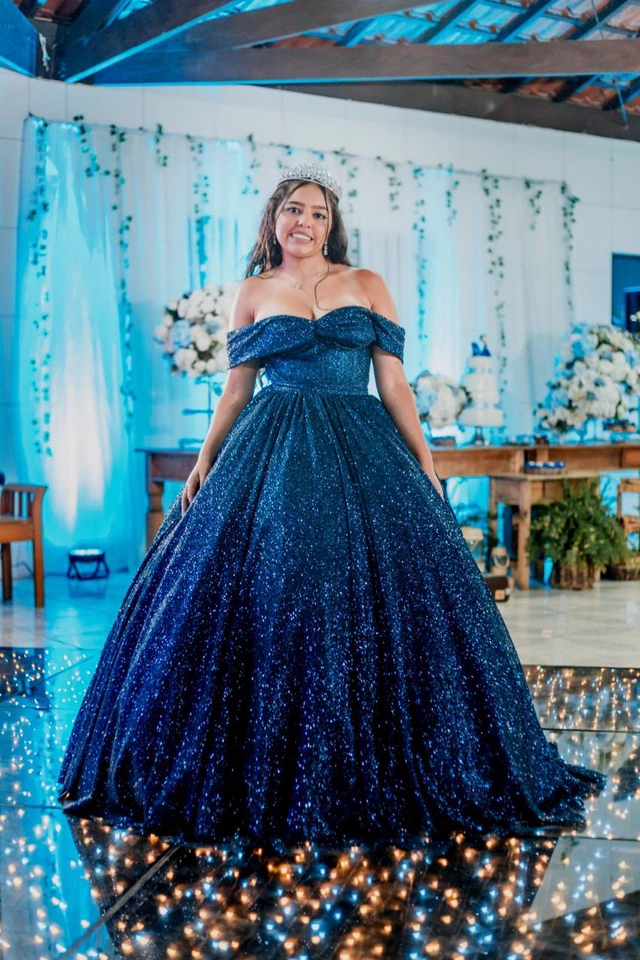 Debutante de vestido azul no salão decorado