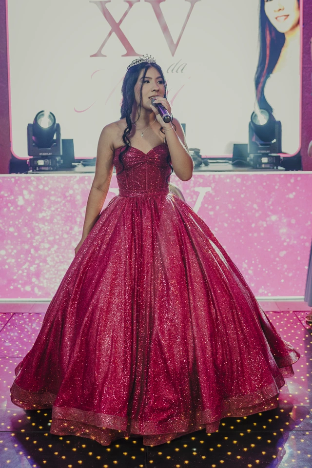 Debutante de vestido vermelho cantando na festa