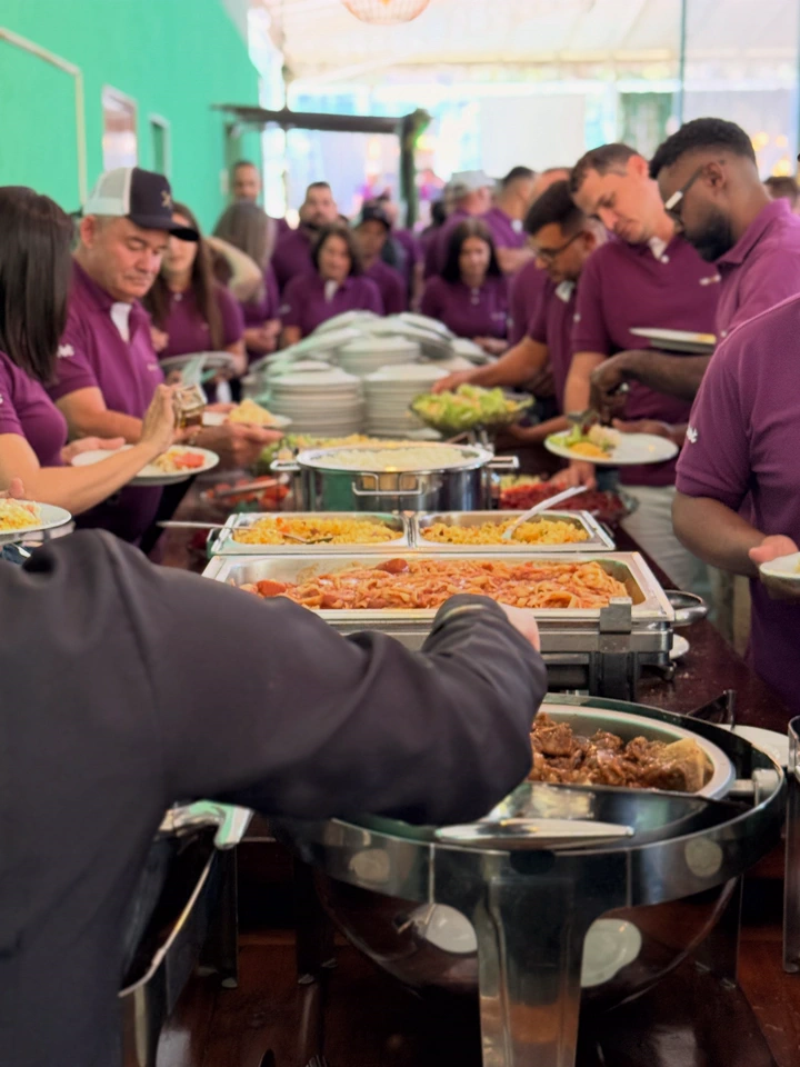 Convidados se servindo no buffet de uma confraternização corporativa