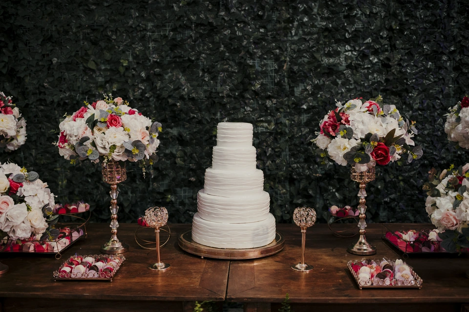 Mesa do bolo de 15 anos decorada com flores