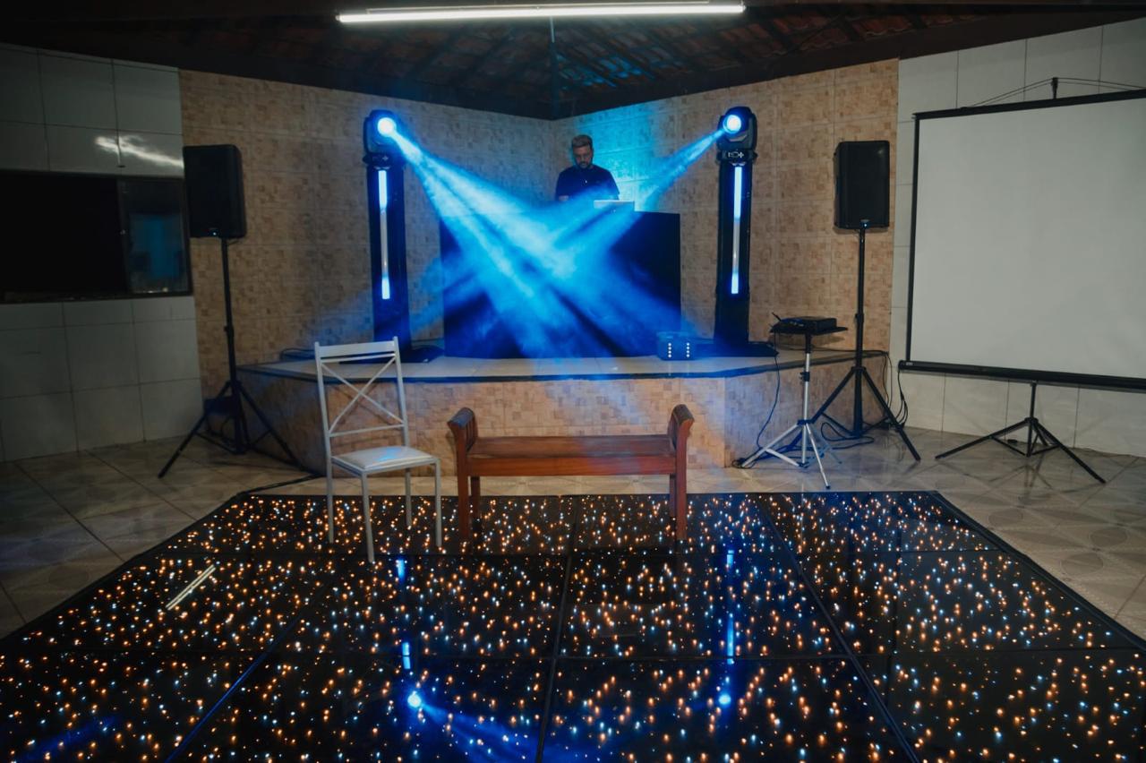 DJ com iluminação azul em pista de LED