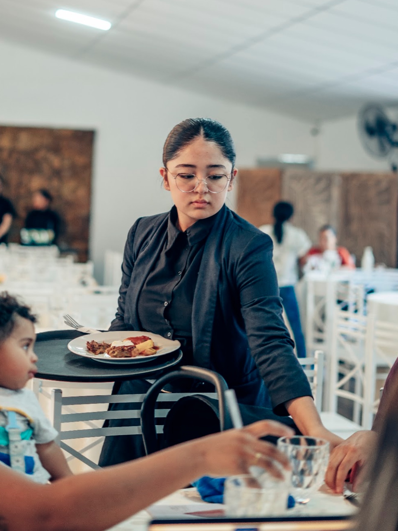 Garçonete servindo convidada