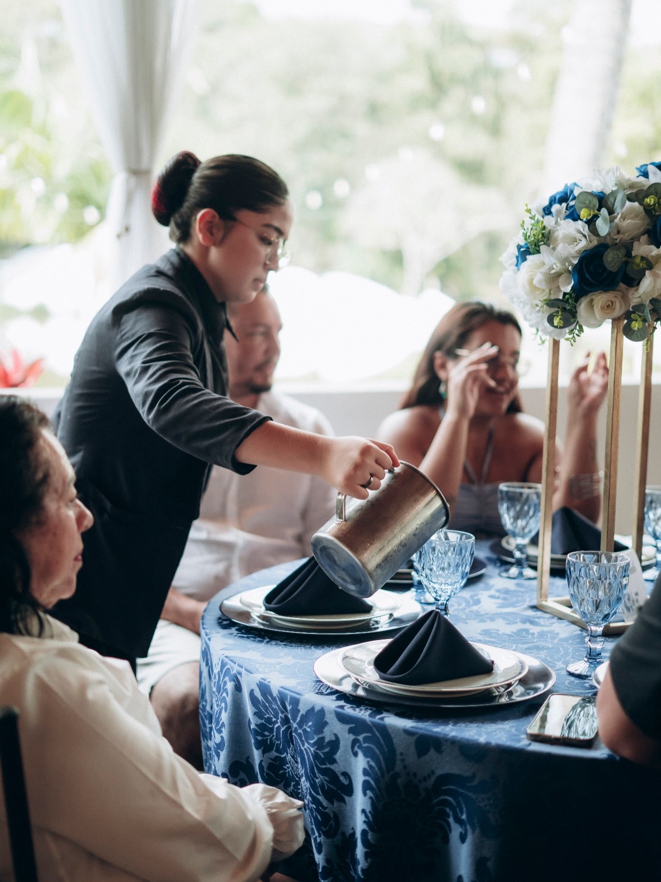 Garçom servindo convidados à mesa
